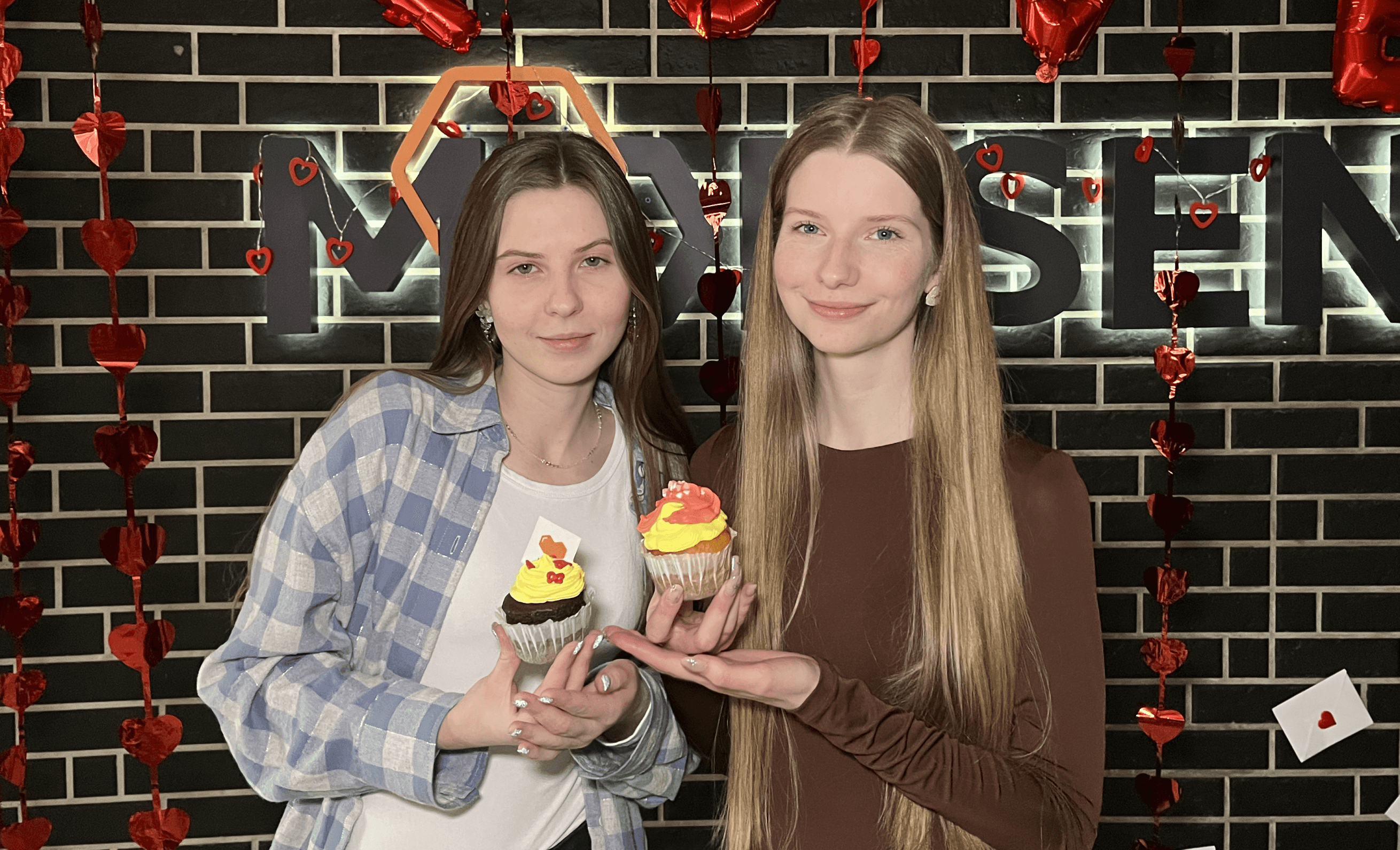 Two girls holding Valentine's Day cupcakes Two girls holding Valentine's Day cupcakes